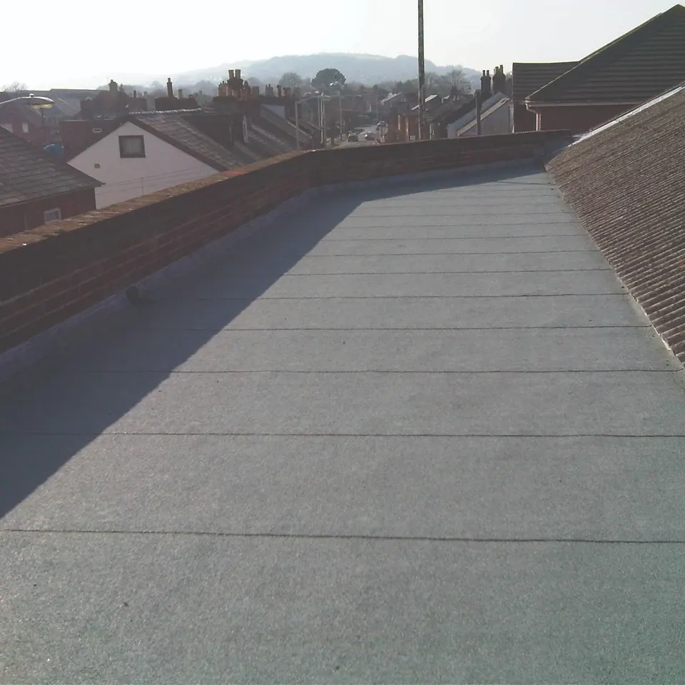 Long flat roof renewed between two brick parapet walls