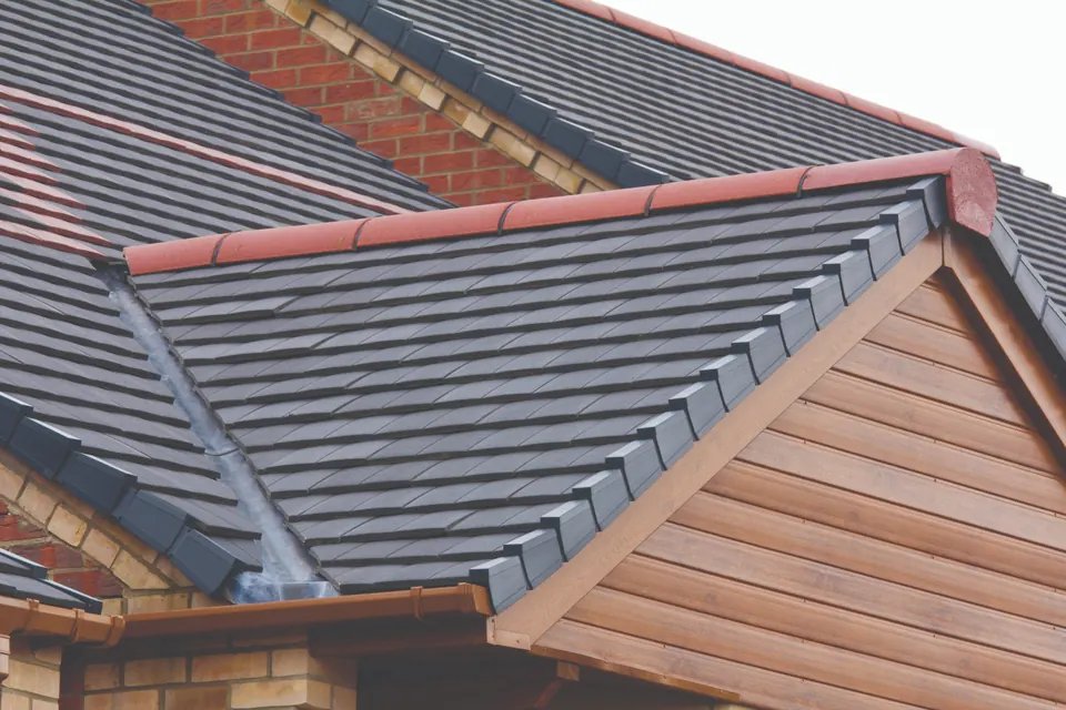 New grey tiled roof with a red ridge above timber-effect gable cladding