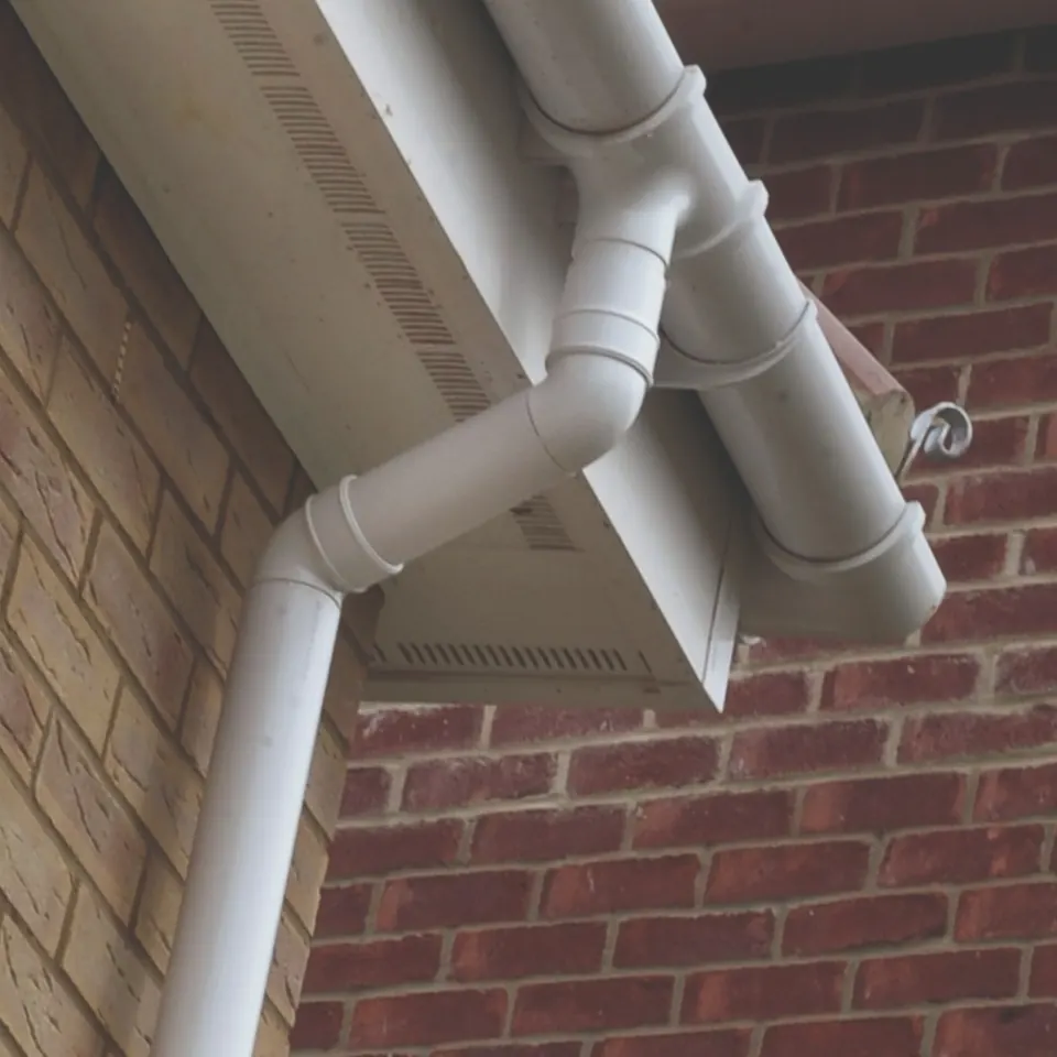 White UPVC soffit, fascia, guttering and downpipe on a brick house